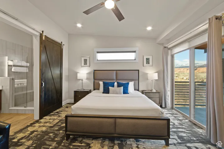 Bedroom with access to exterior, a barn door, a ceiling fan, recessed lighting, and ensuite bath