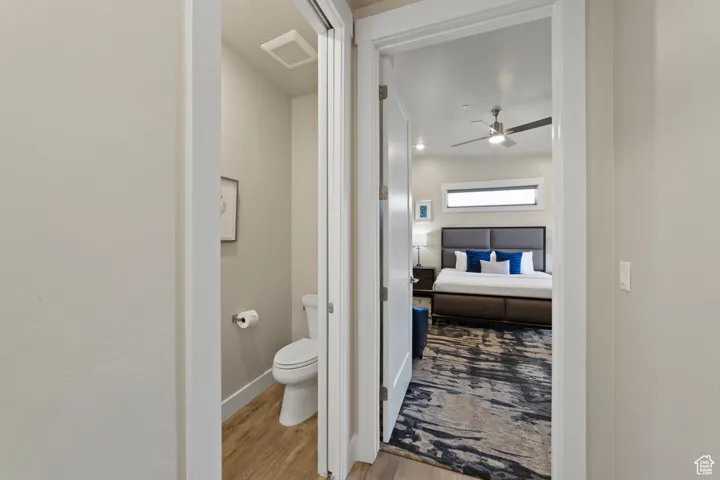 Bathroom with light wood-style floors and a ceiling fan