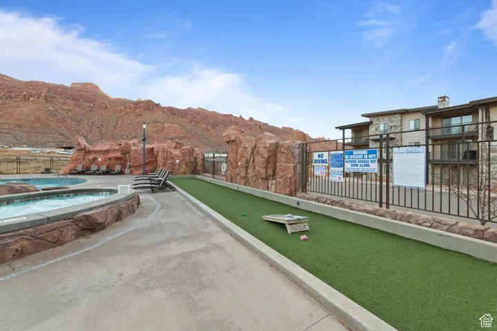 View of property's community with a game area, a jacuzzi, and a mountain view