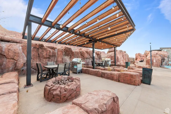 View of patio / terrace with outdoor dining space, a pergola, area for grilling, and an outdoor fire pit