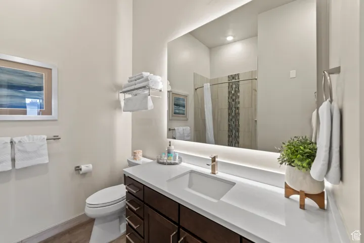 Bathroom featuring vanity, a shower stall, and dark wood-type flooring