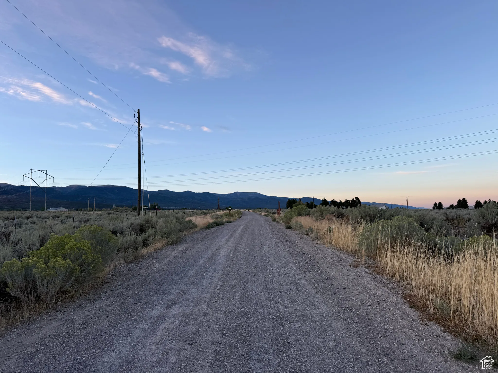 View of dirt / gravel road featuring a mountain view and a view of countryside
