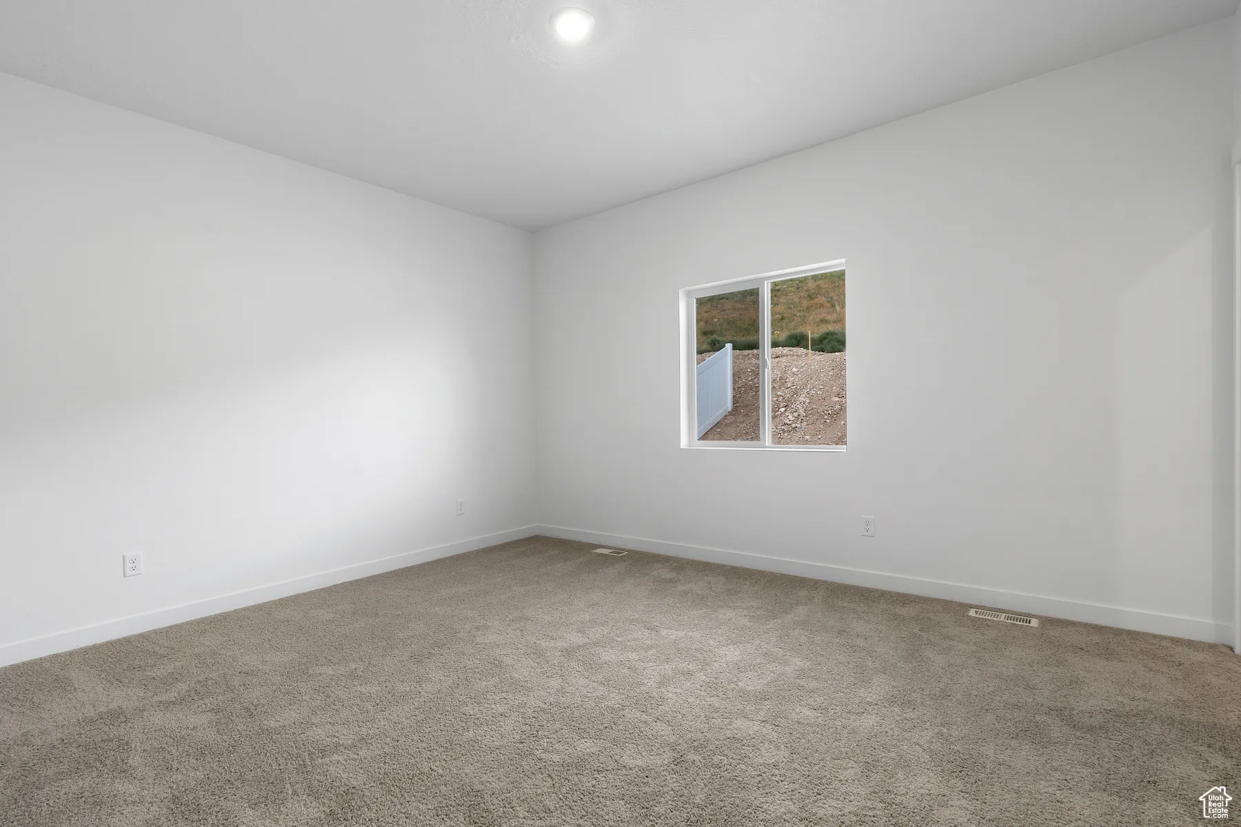 Spare room with light carpet and baseboards