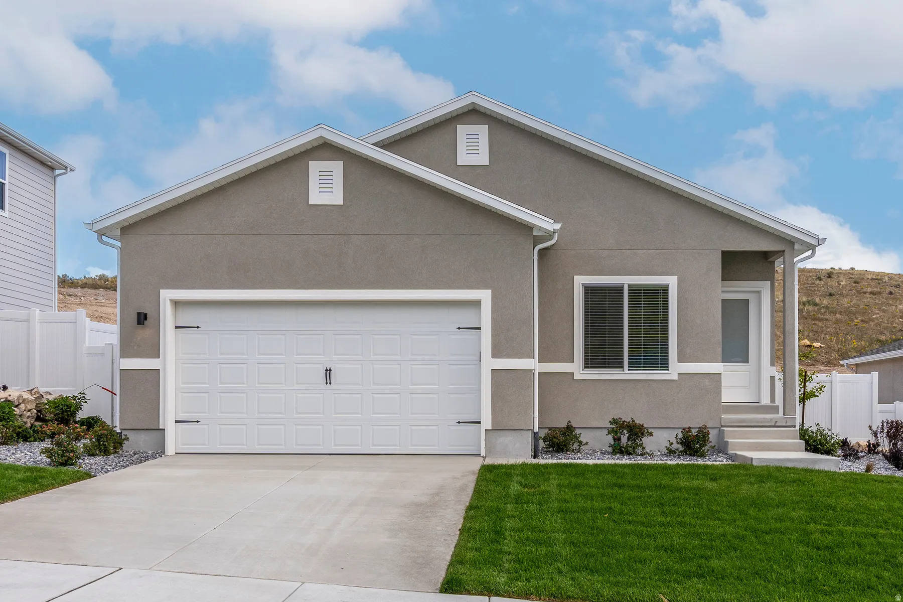 Contemporary single-story residence featuring a stucco exterior with white trim accents
