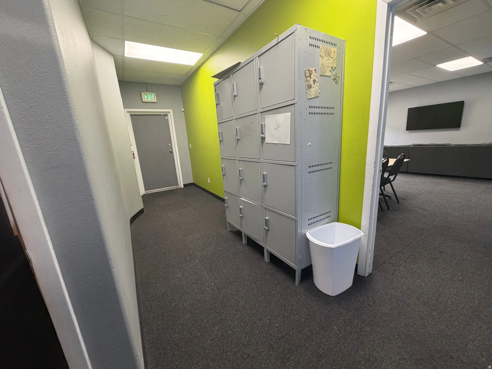 Interior hallway with grey carpet flooring and contrasting lime green accent wall