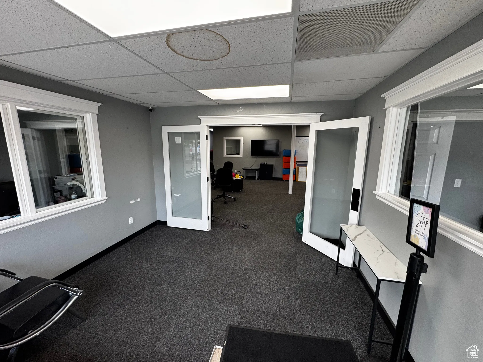 Exercise room with a drop ceiling and french doors
