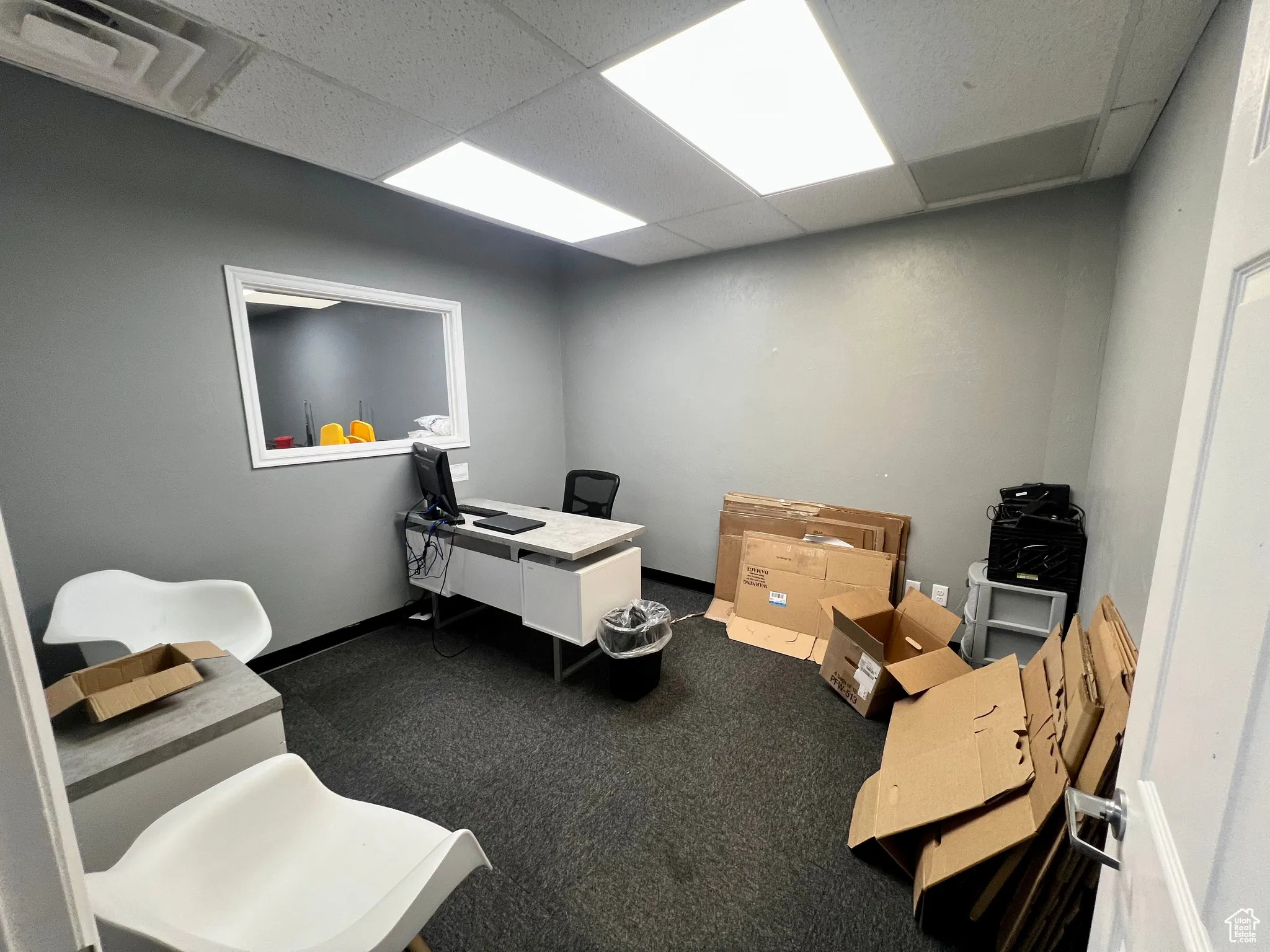 Office with a paneled ceiling and carpet flooring