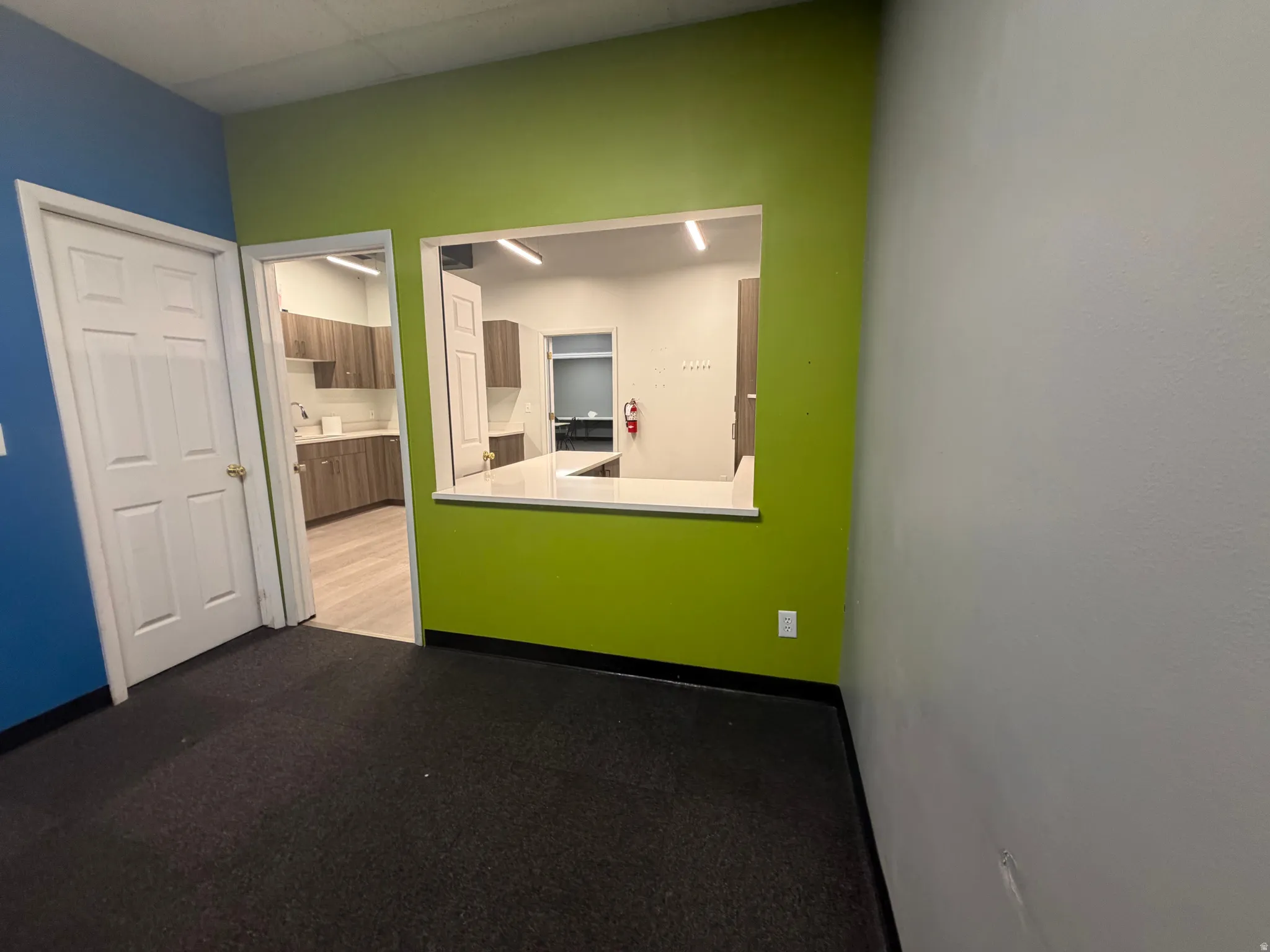 Flexible open area featuring a pass-through window with a white countertop