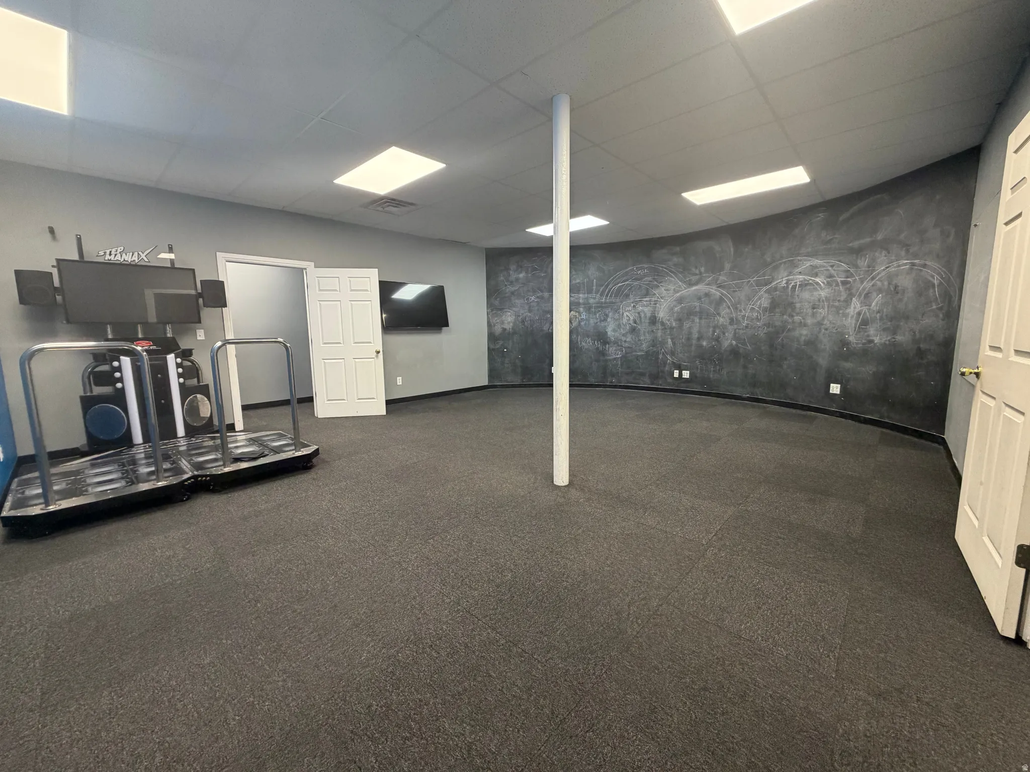 Spacious interior room featuring dark gray carpeting and light gray walls