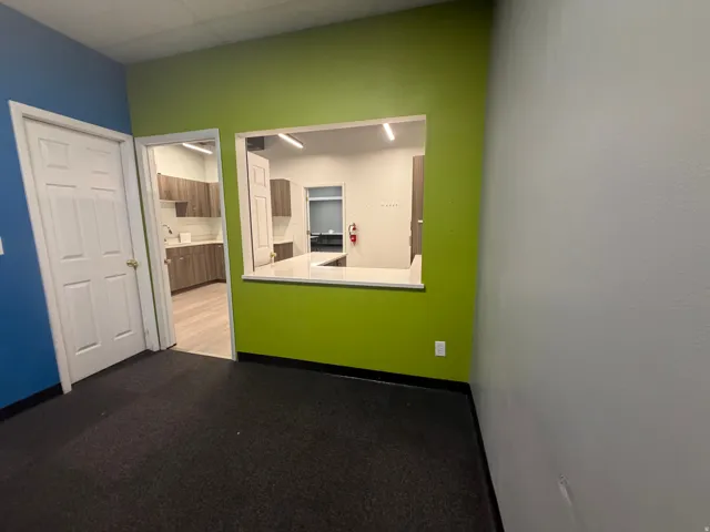 Flexible open area featuring a pass-through window with a white countertop