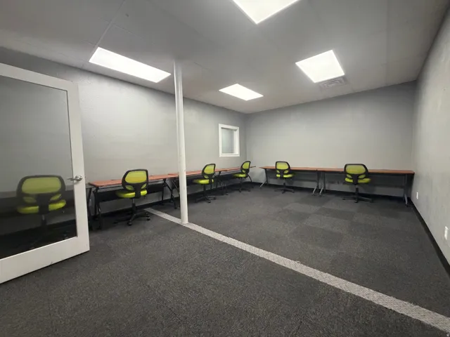 Spacious room featuring modular carpet tile flooring, a window, and recessed rectangular lighting