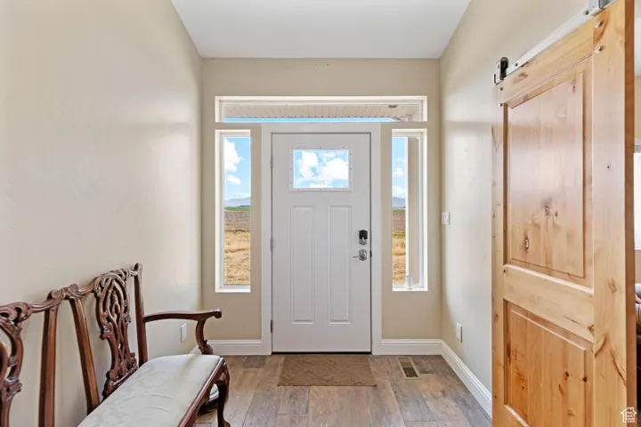 Foyer featuring a barn door and light wood finished floors