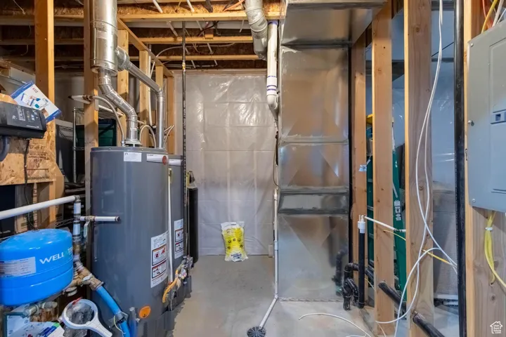 Utilities featuring electric panel, water heater, and heating unit