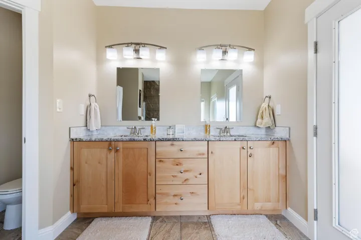 Main bathroom with double vanity and toilet room.