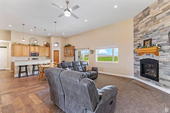 Living area with a fireplace, recessed lighting, a ceiling fan, and light wood-style floors