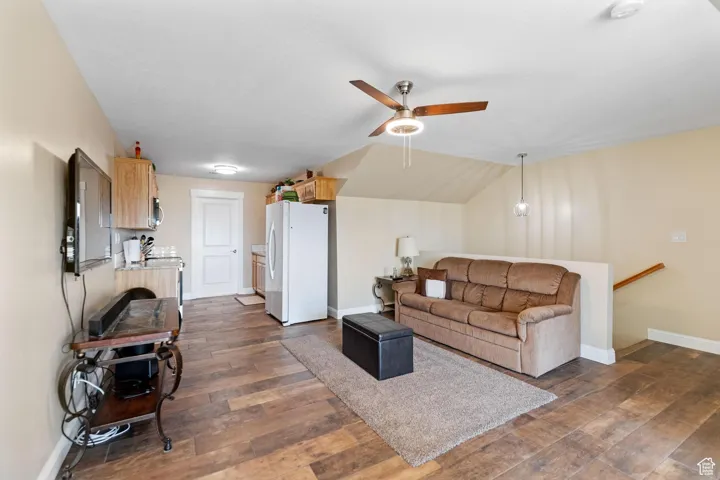 ADU: Living area featuring dark wood-type flooring, a ceiling fan, and lofted ceiling