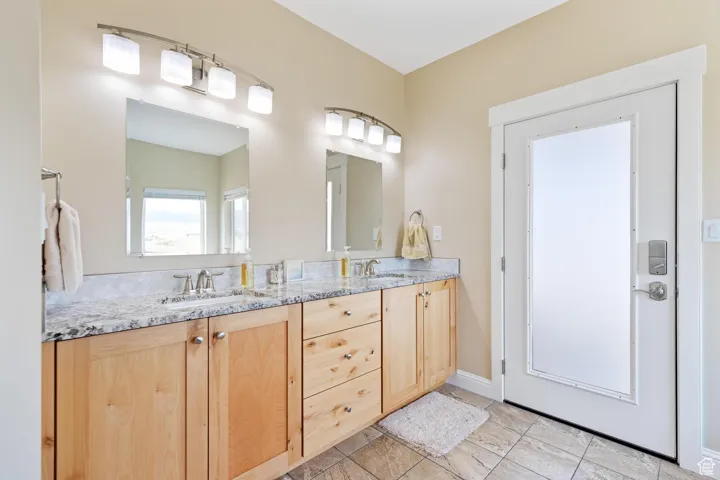 Main Bathroom with double vanity and baseboards