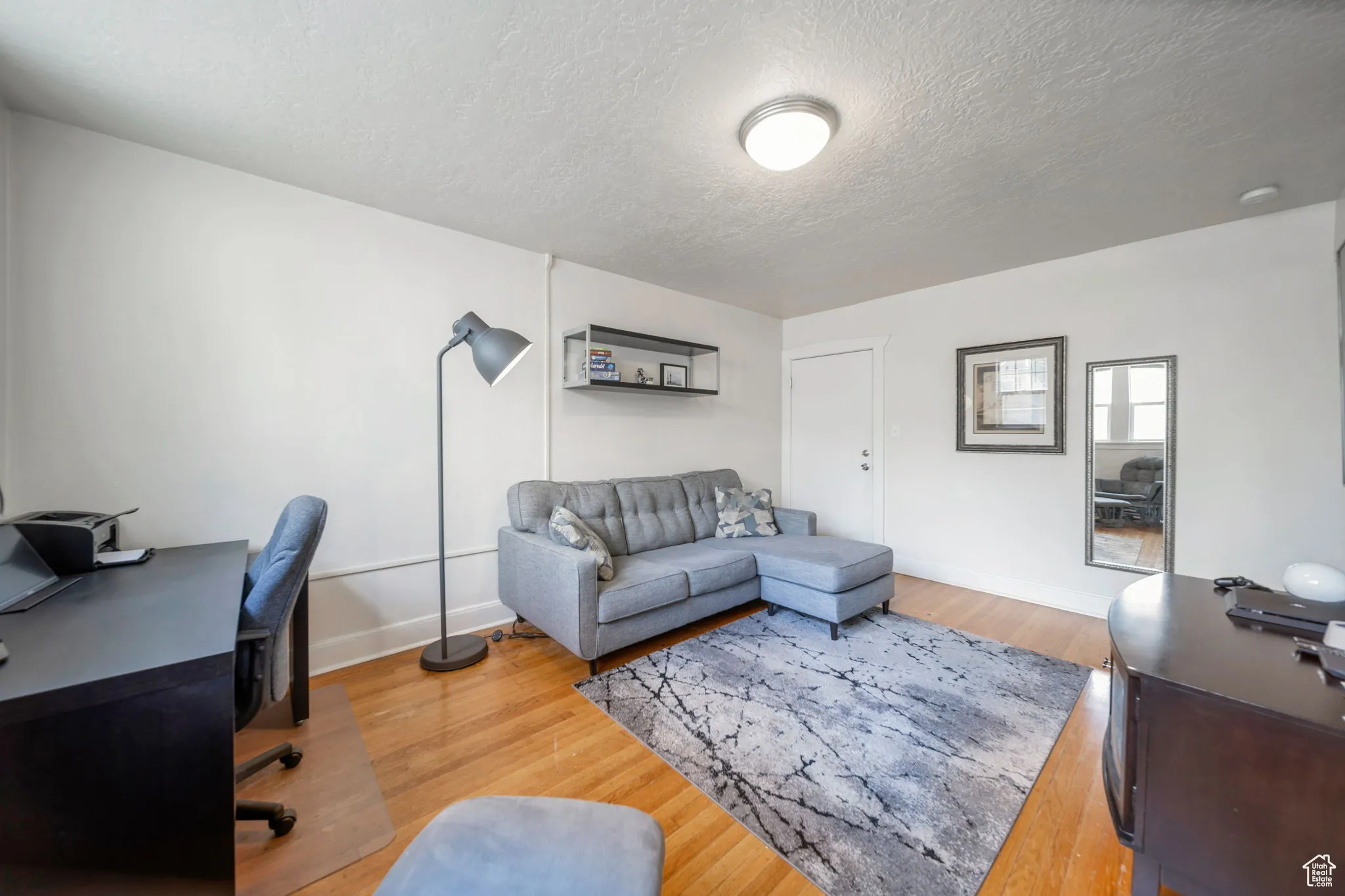Office space featuring light wood finished floors and a textured ceiling
