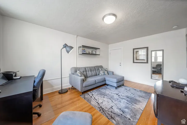 Office space featuring light wood finished floors and a textured ceiling