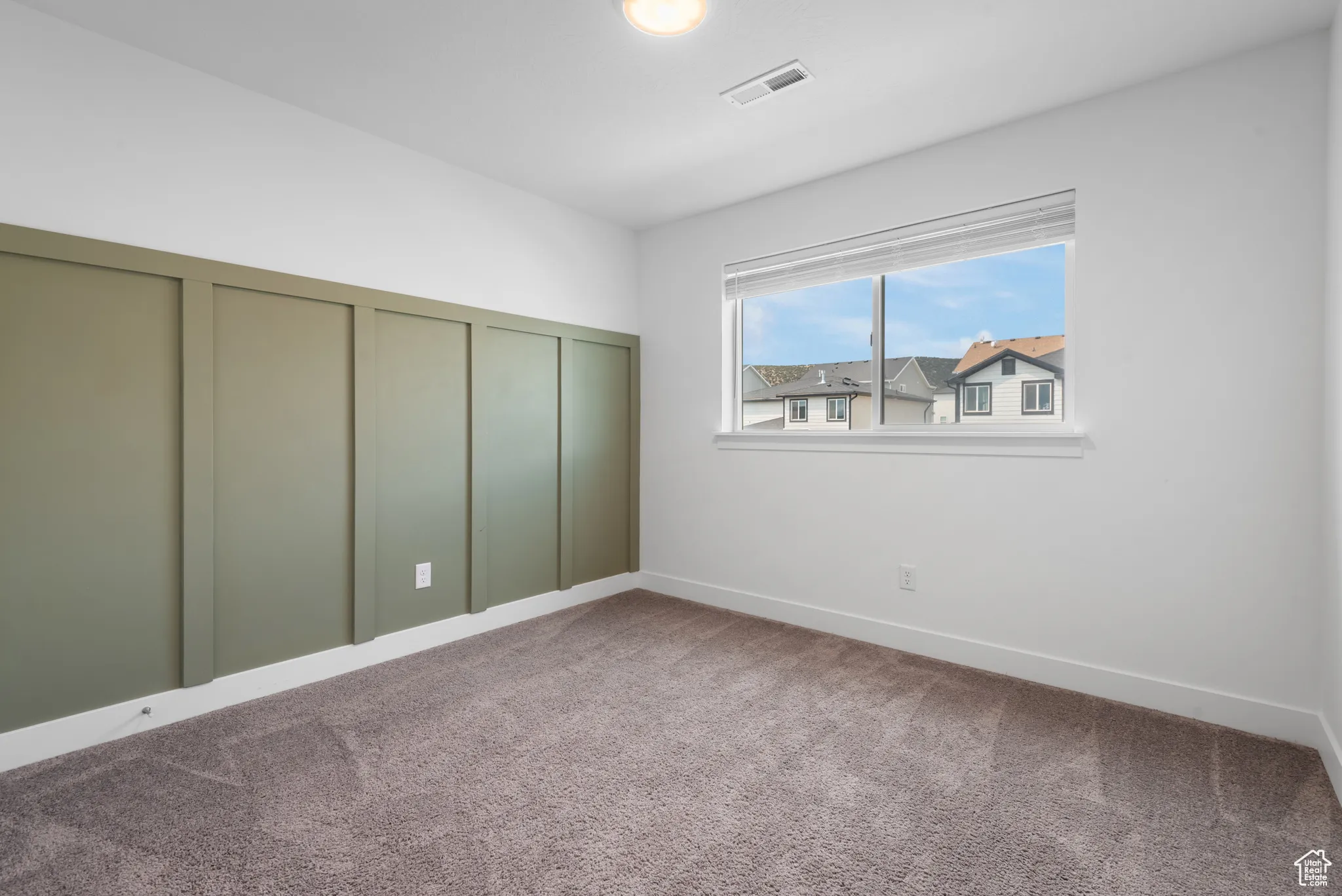 Unfurnished bedroom with carpet flooring and baseboards