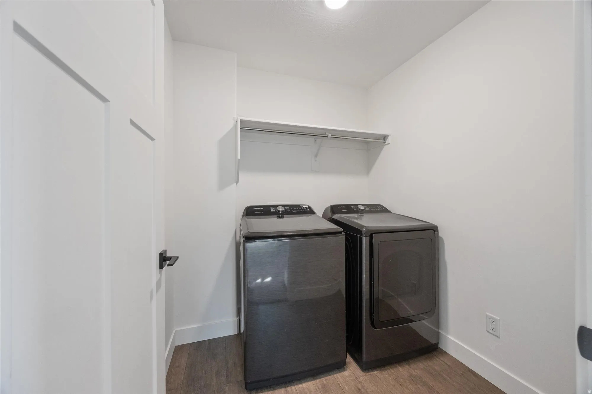 Laundry area featuring dark wood finished floors and washer and clothes dryer