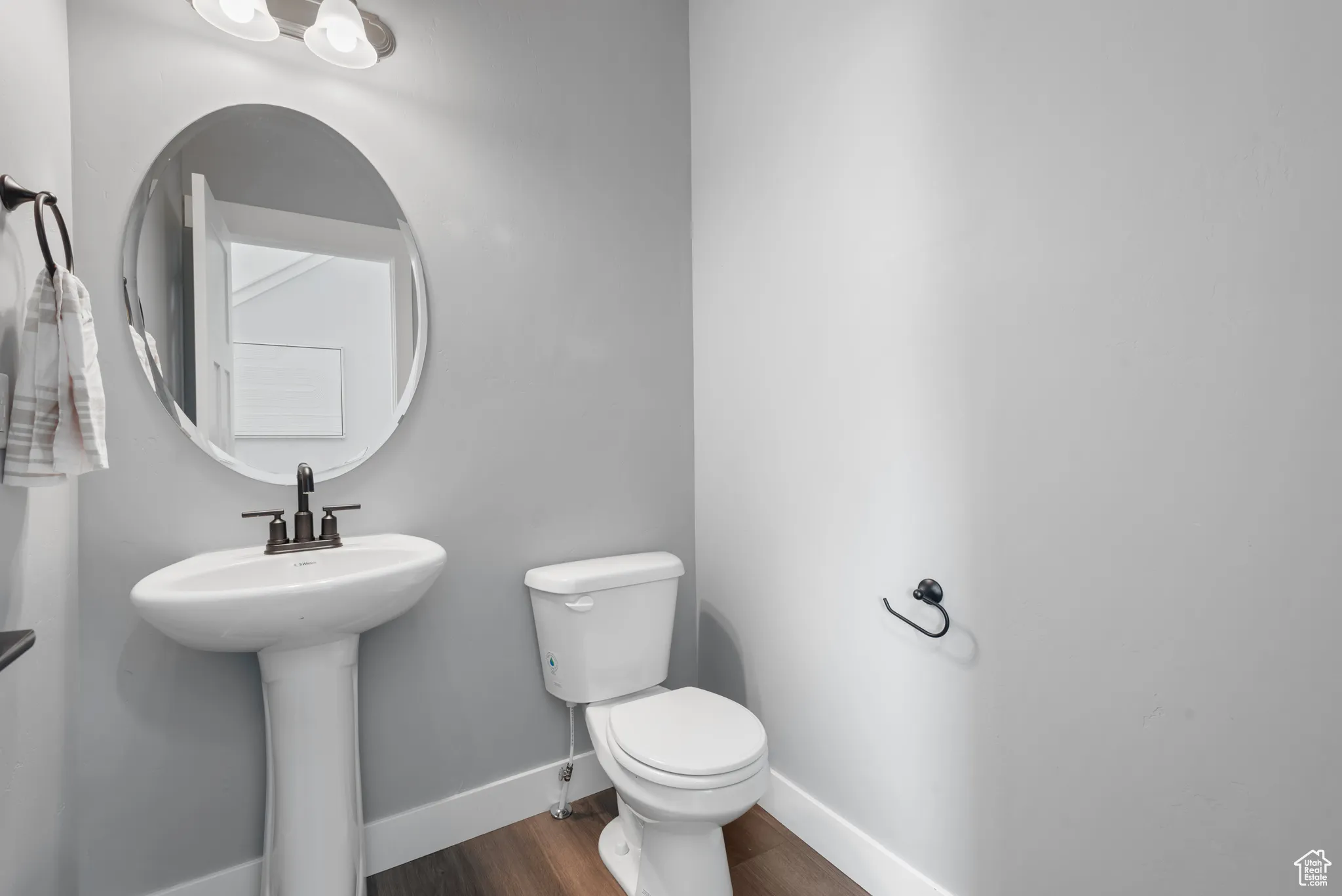 Half bath featuring baseboards and dark wood-type flooring
