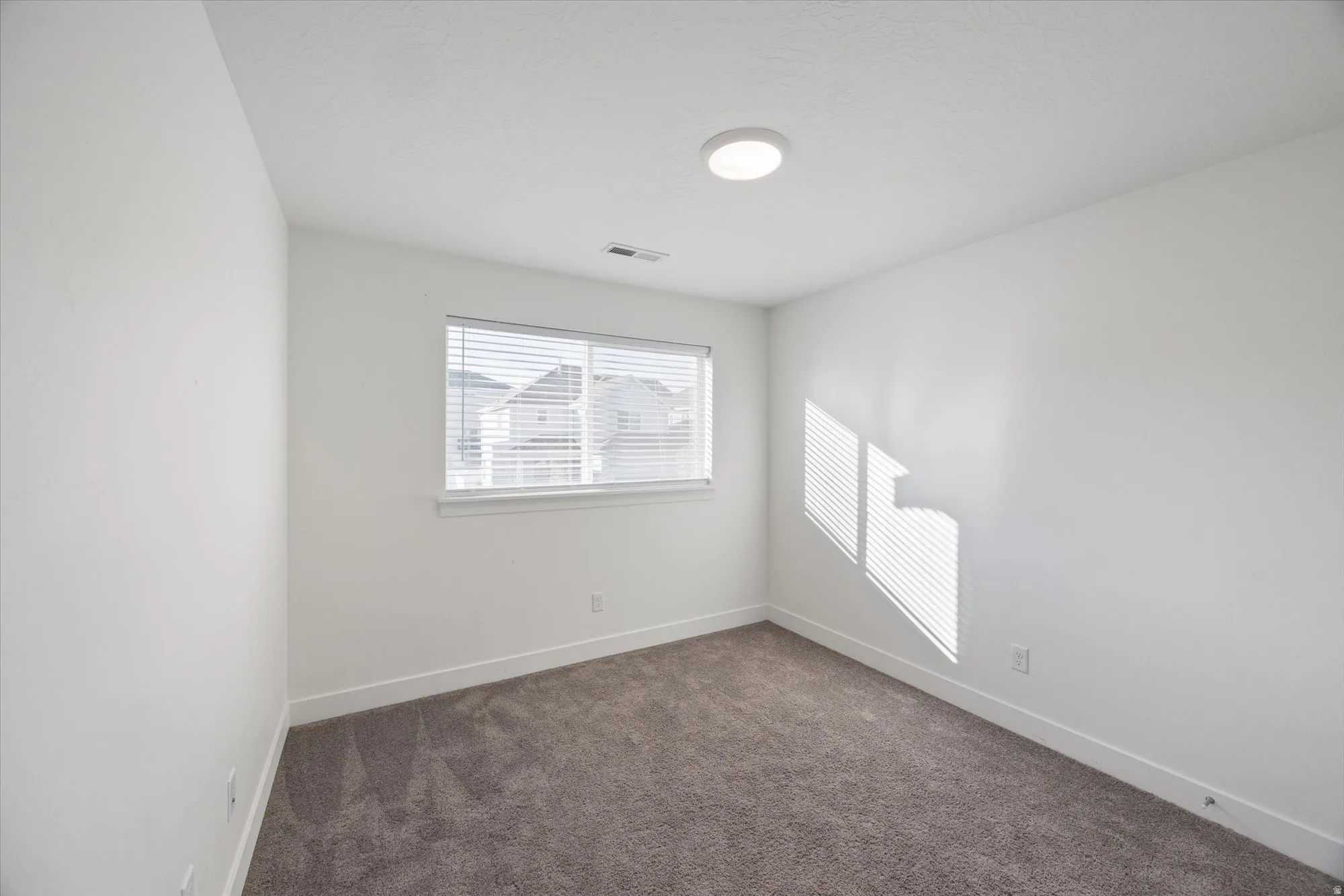 Carpeted spare room with baseboards