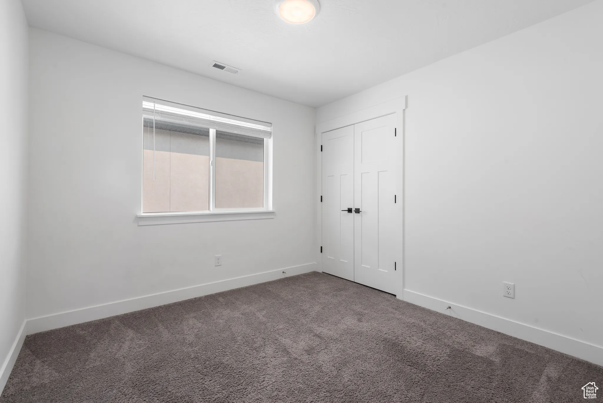 Unfurnished bedroom featuring carpet flooring and a closet