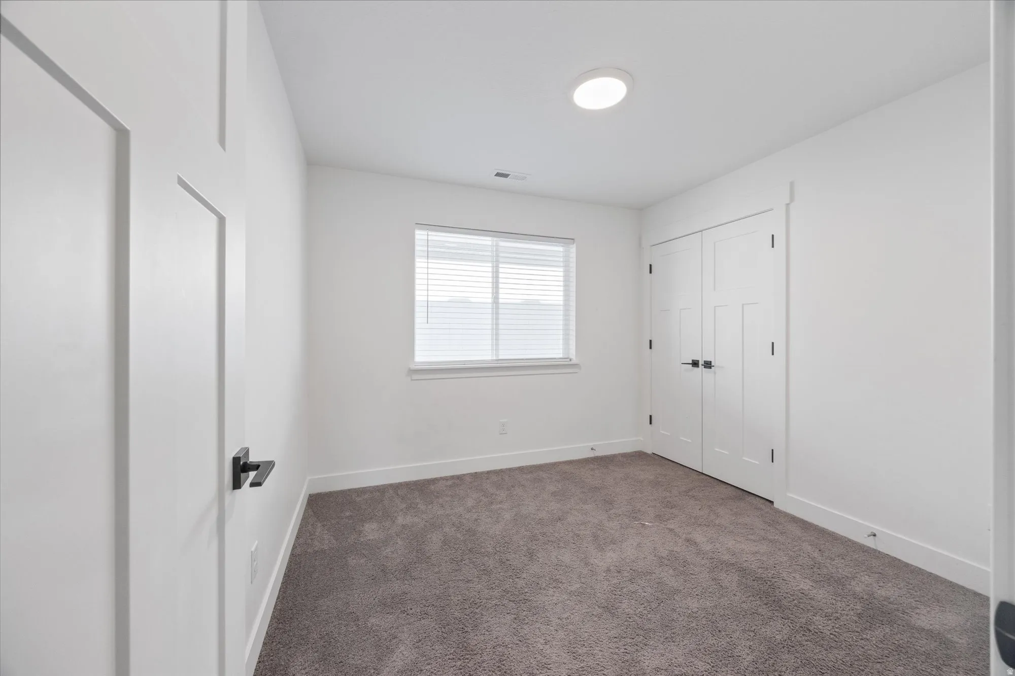 Unfurnished bedroom featuring carpet flooring and a closet