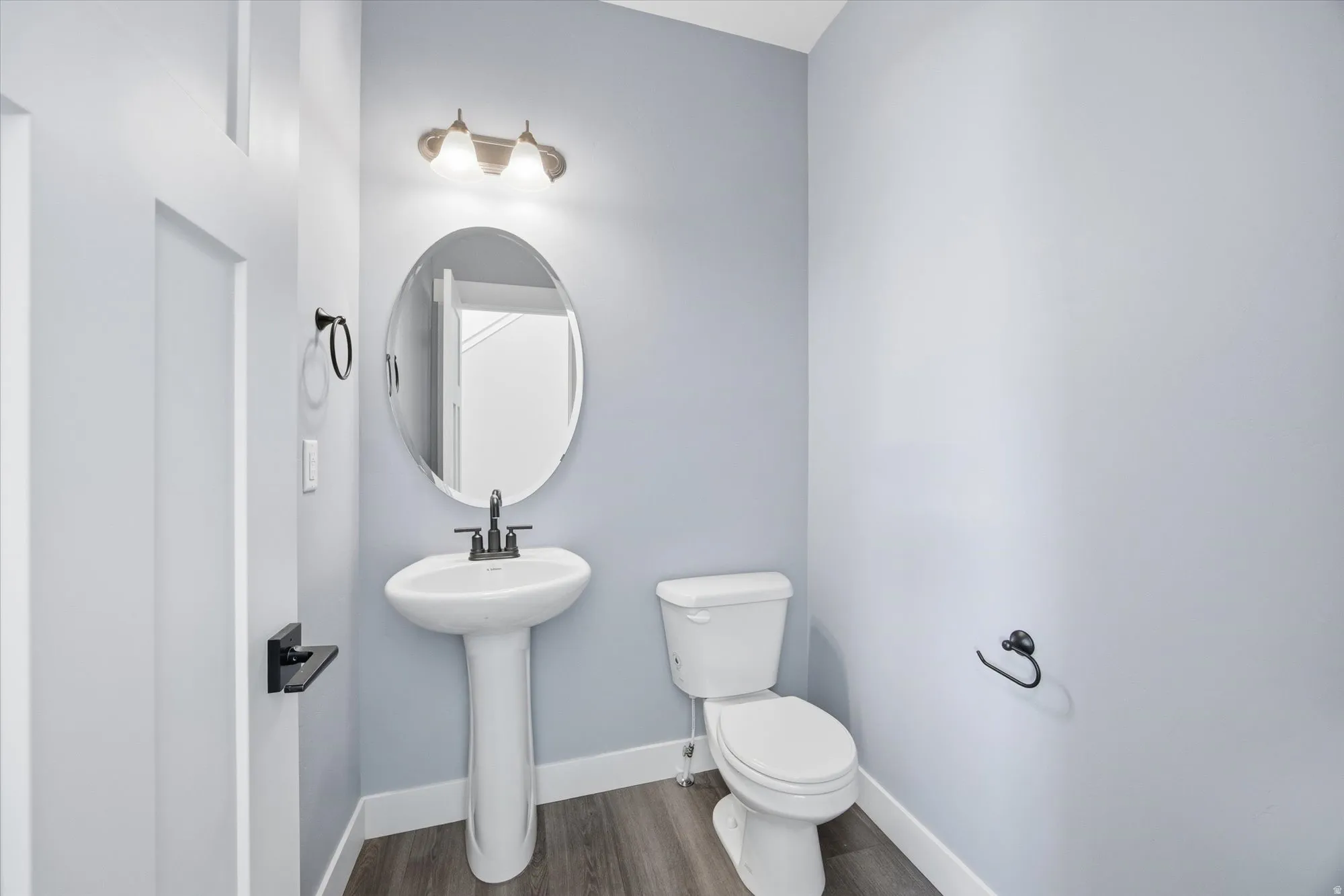 Half bath featuring baseboards and dark wood-style floors