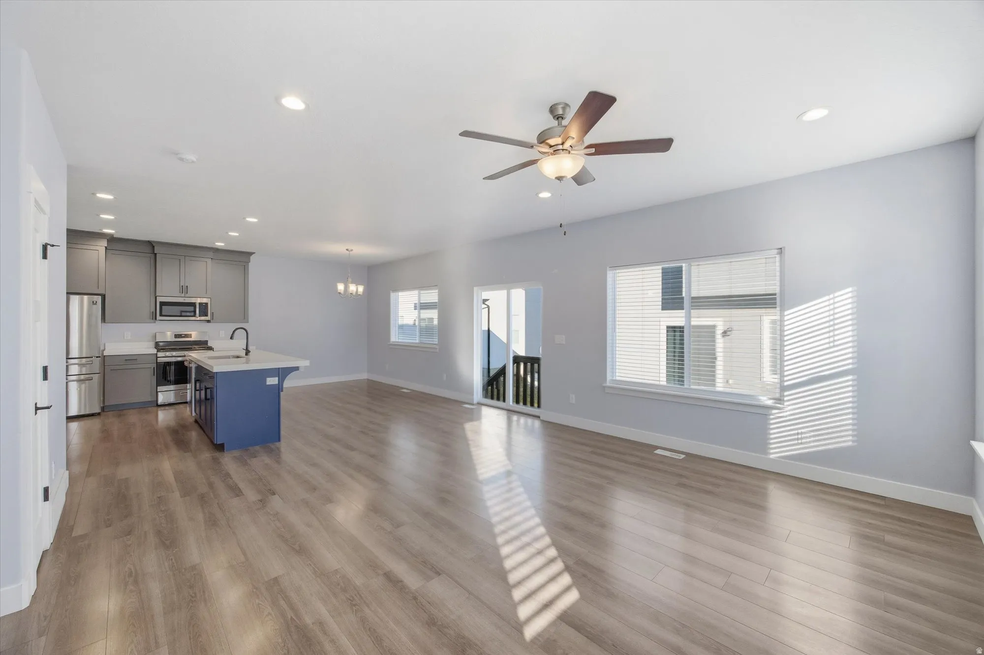 Kitchen featuring stainless steel appliances, a center island with sink, open floor plan, recessed lighting, and a ceiling fan
