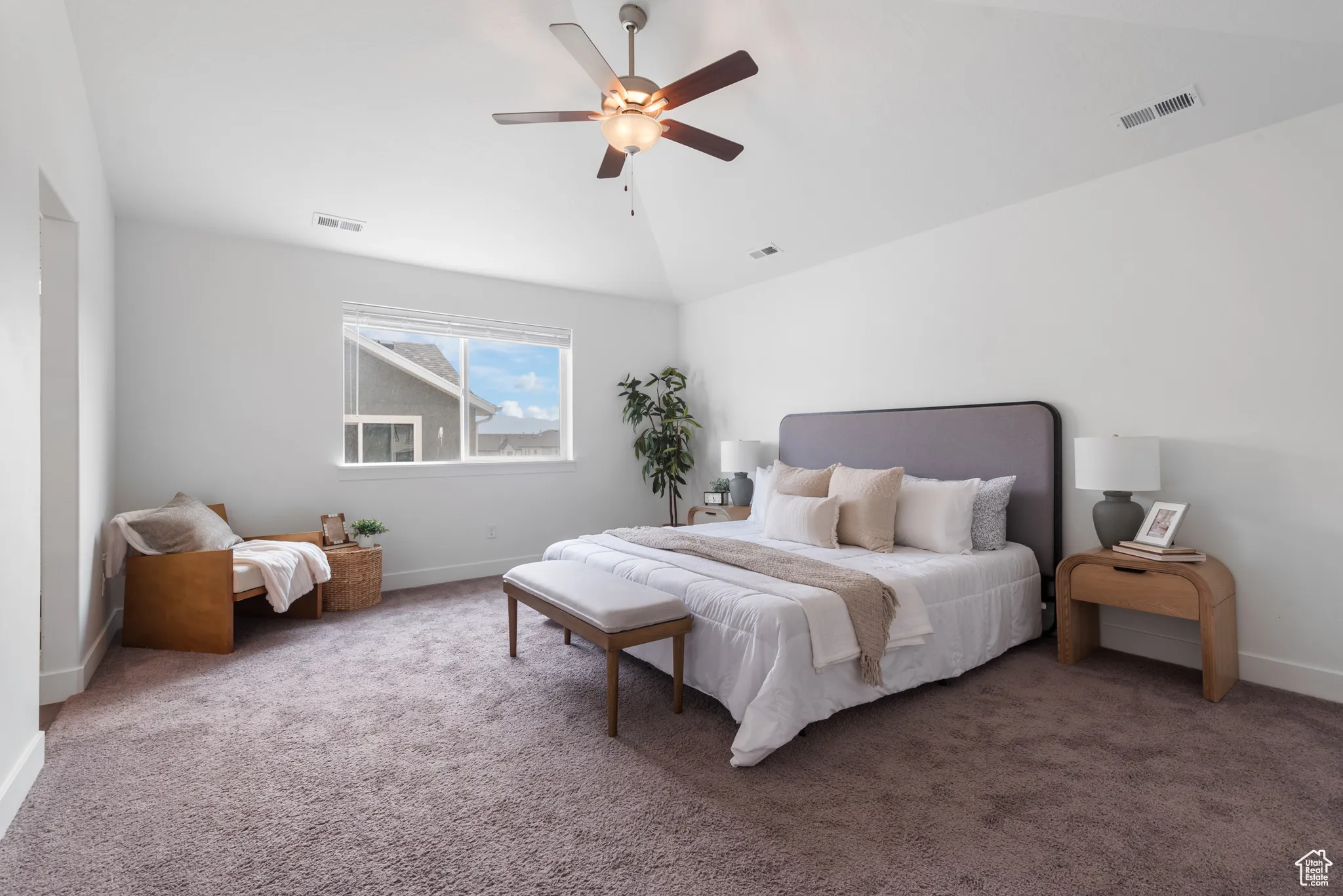 Bedroom with vaulted ceiling, carpet flooring, and a ceiling fan