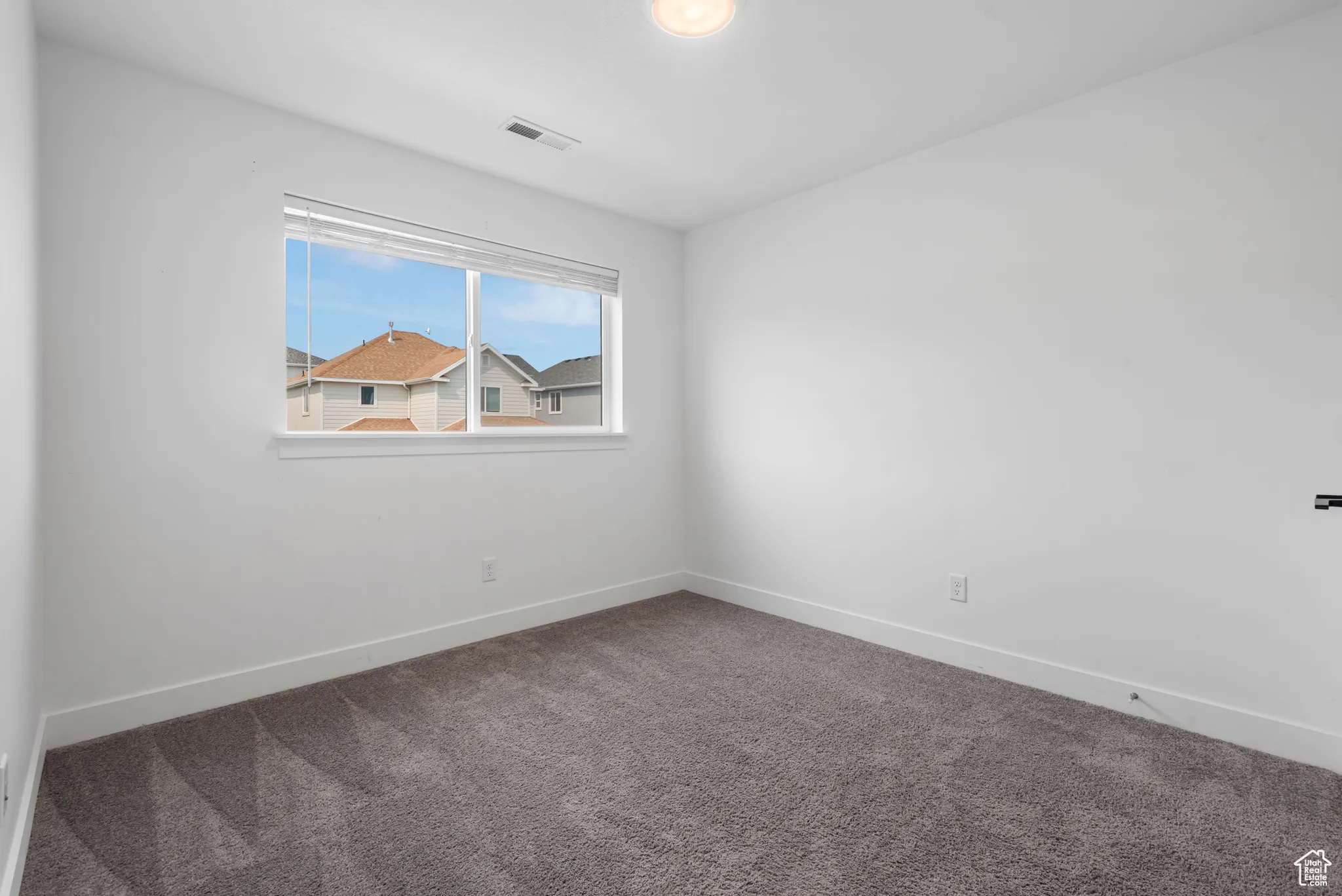Carpeted empty room with baseboards