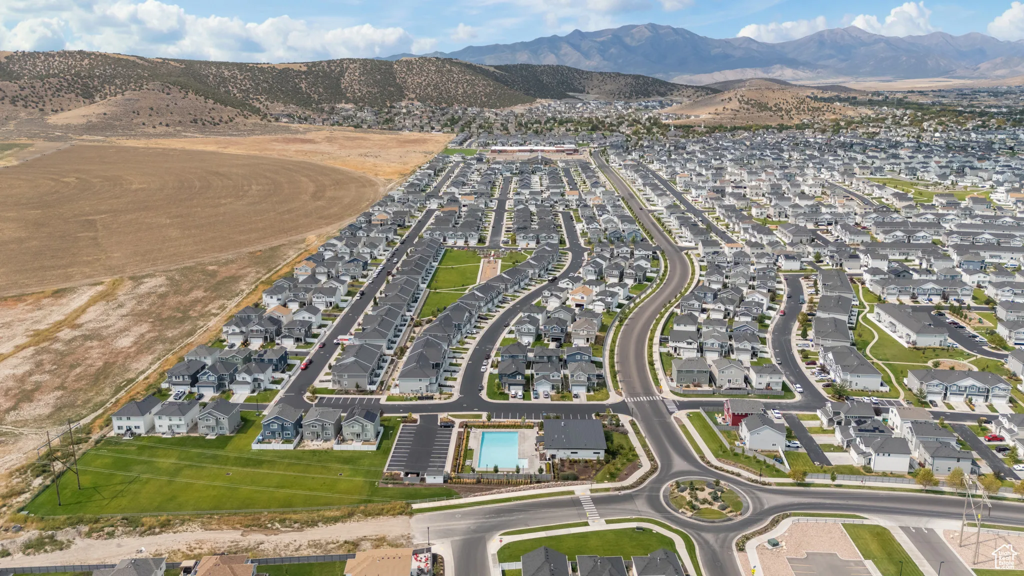 Aerial view of property and surrounding area with mountains and nearby suburban area