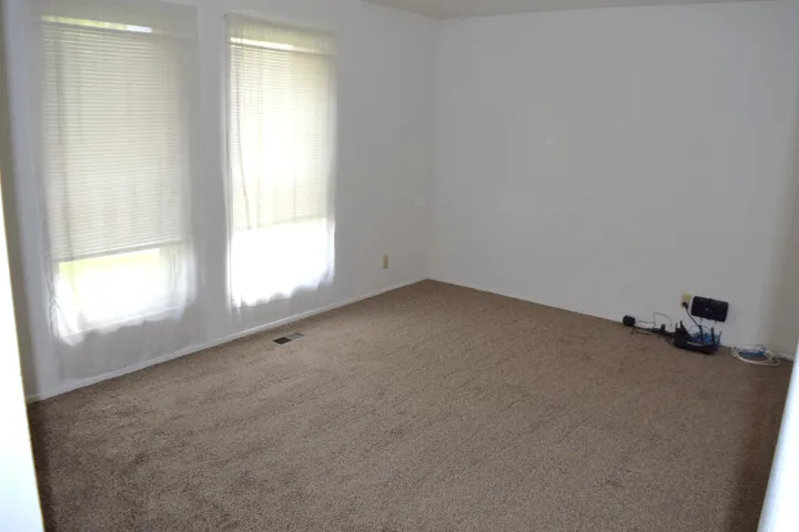 Empty room featuring carpet flooring and baseboards