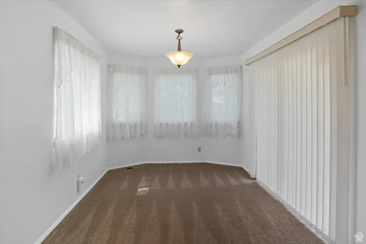 Dining area with dark carpet and white baseboards