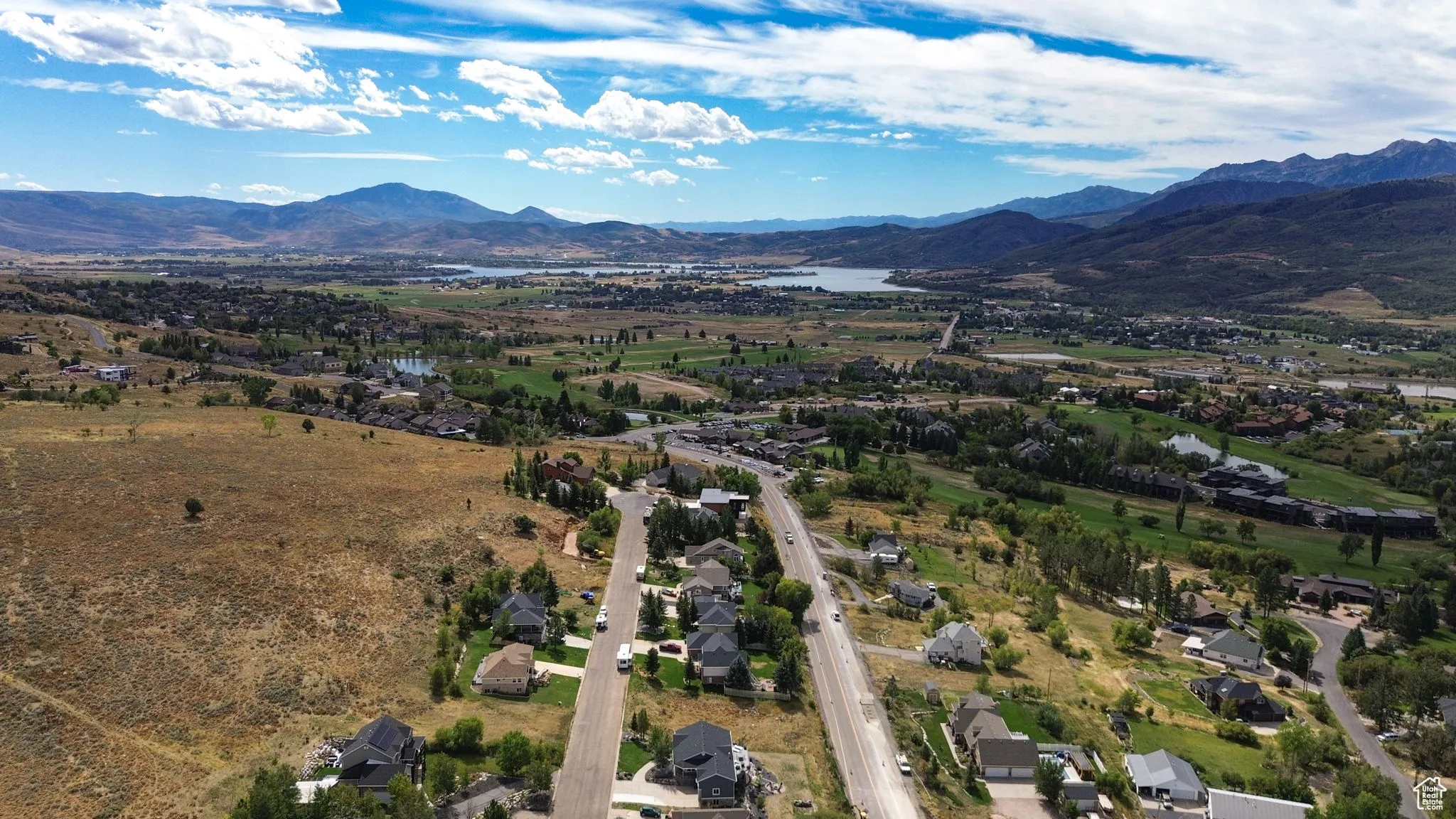 Aerial overview of property's location featuring a water and mountain view and nearby suburban area