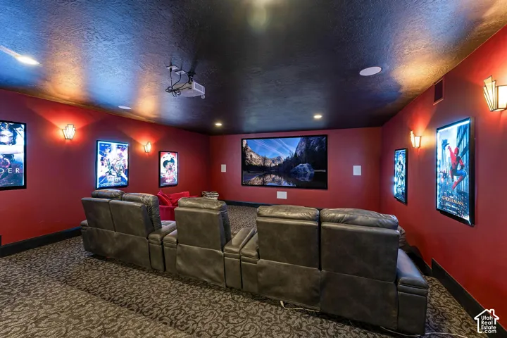 Carpeted home theater room featuring a textured ceiling and recessed lighting