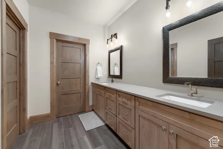 Bathroom with double vanity and dark wood finished floors