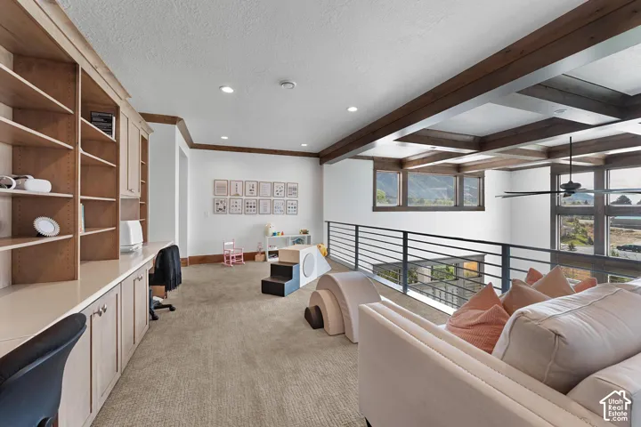 Sitting room featuring light colored carpet, built in desk, beam ceiling, recessed lighting, and a textured ceiling
