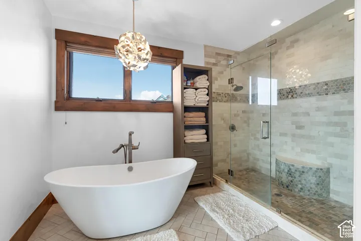 Full bathroom with a chandelier, tile patterned flooring, a freestanding bath, a shower stall, and recessed lighting