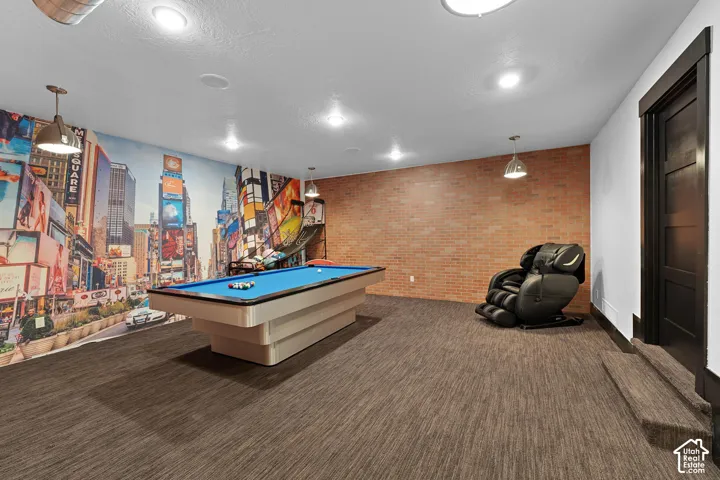 Recreation room featuring billiards, dark colored carpet, brick wall, a textured ceiling, and recessed lighting