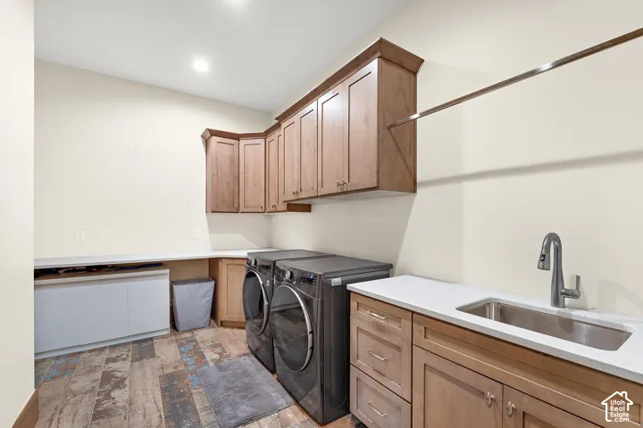 Laundry area featuring cabinet space, washer and clothes dryer, light wood-style floors, and recessed lighting