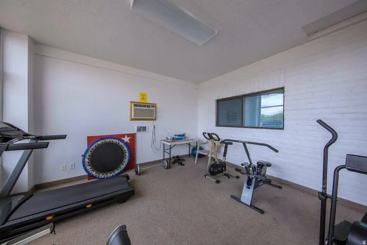 Carpeted interior space with a window air conditioning unit and a horizontal window