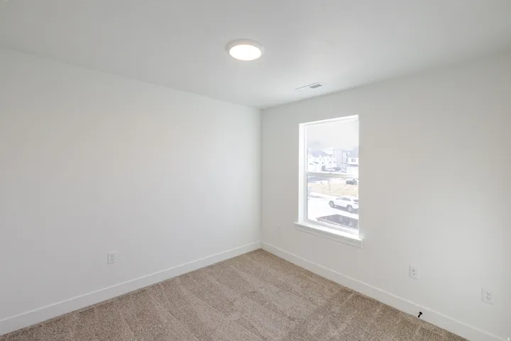 Carpeted spare room with baseboards