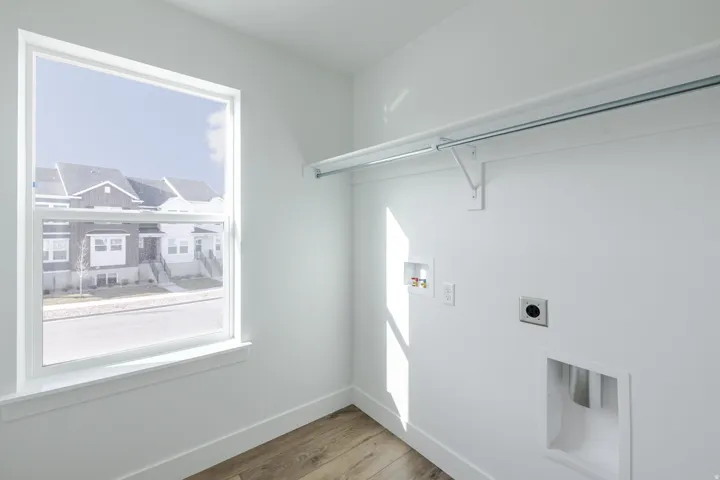 Laundry area with hookup for a washing machine, light wood finished floors, and hookup for an electric dryer