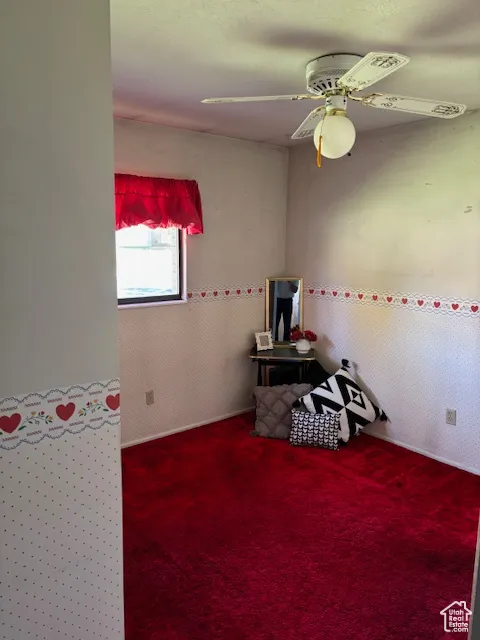 Recreation room with carpet flooring, a ceiling fan, and wallpapered walls
