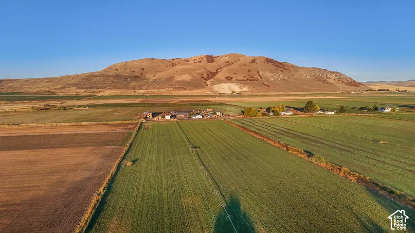 Aerial view of sparsely populated area with a mountain backdrop and farmland