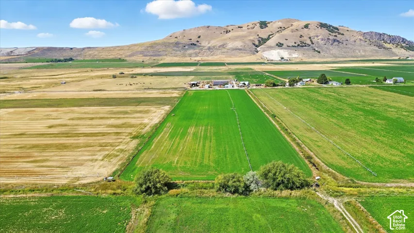 Aerial view of property and surrounding area with a mountain backdrop, rural landscape, and extensive farmland
