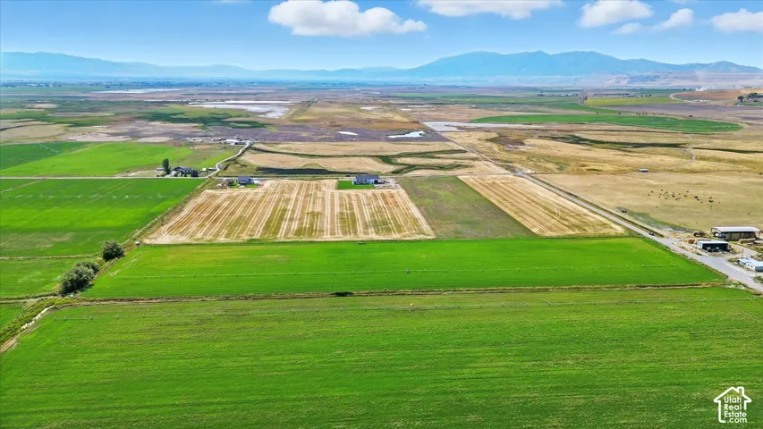 Aerial view of sparsely populated area featuring a mountain backdrop and extensive farmland
